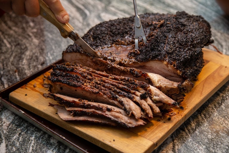Juicy smoked beef brisket being sliced fresh off the smoker on a cutting board