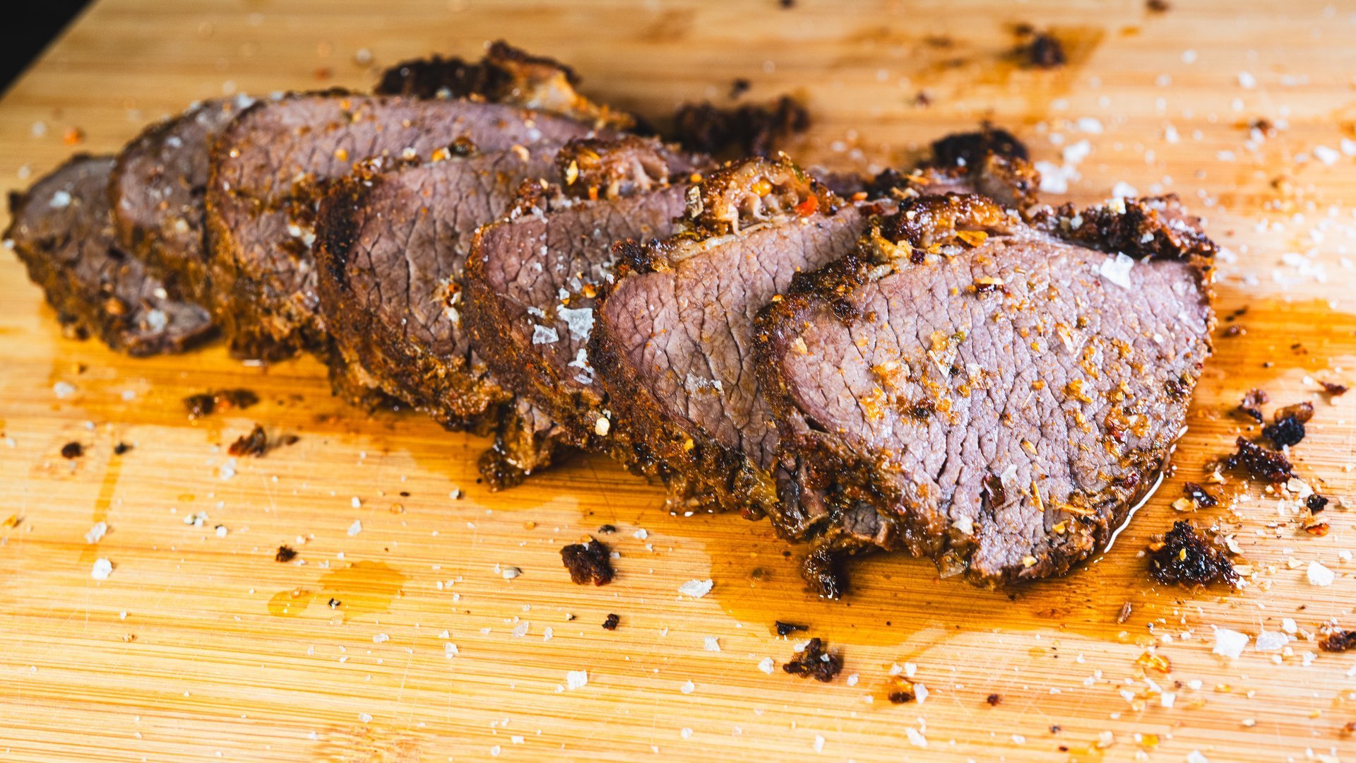 Fresh sliced smoked brisket with heavy rub seasoning, steam rising from hot juicy meat - Scootrz Deli & BBQ Ukiah