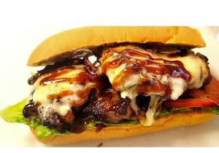 Gourmet cheeseburger with melted cheese, caramelized onions, and barbecue sauce on a toasted bun