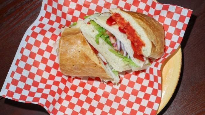 Sandwich cut in half on red and white checkered paper