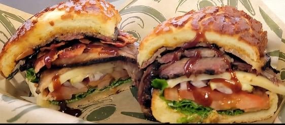 Two gourmet burgers with bacon and cheese